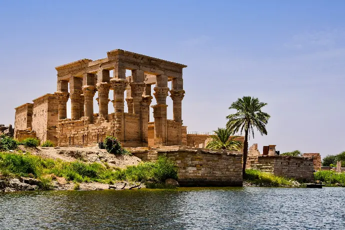 Philae with columns and a palm tree by a body of water